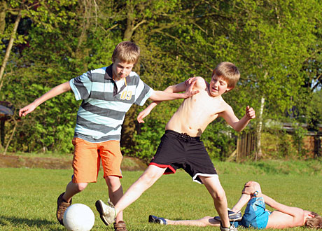 Fotbollsspelande ungdomar på gräsplan