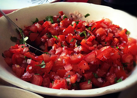 vackert röd tomat- och myntasallad i vit skål