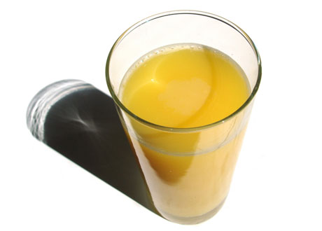 ett glas apelsinjuice mot vit bakgrund
