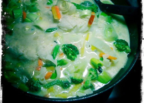 Fiskgryta med grönsaker och grön curry i blå skål