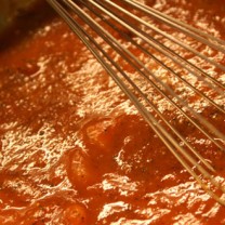 Vckert röd tomatsås kokas och visas