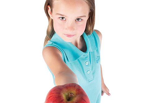 Söt tjej i åttaårsåldern håller fram ett äpple