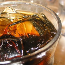 En colafärgad dryck i glas med is