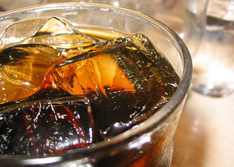 En colafärgad dryck i glas med is