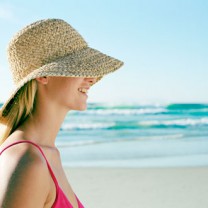 Kvinna i solhatt på en strand