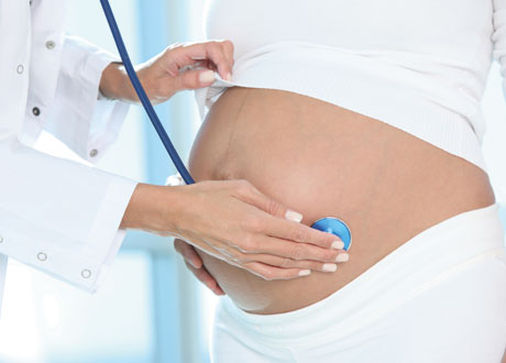 Gravidmage med läkare bredvid