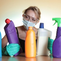Kvinna med munskydd och rengöringsflaskor
