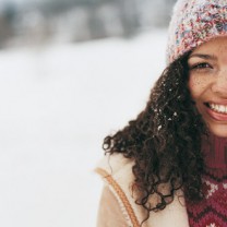 Vacker kvinna med fräknar i snön
