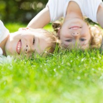 Två glada barn i gräset