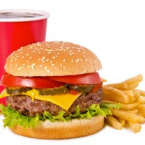 frilagd bild på röd pappmugg med mörk läsk, en hamburgare och pommes