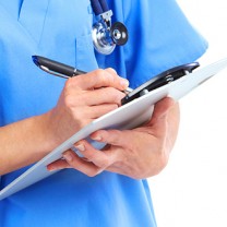 Person i blå läkarrock och stetoskop skriver på anteckningsblock