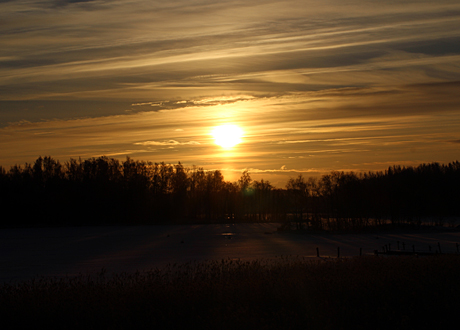 Solnedgang i svenskt vintrigt landskap
