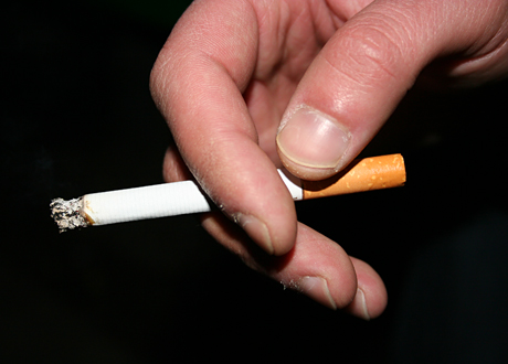 En manshand håller en cigarett