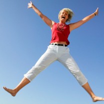 Kvinna hoppar blå himmel som bakgrund