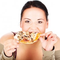 Mörkhårig kvinna äter pizza