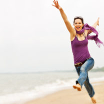 Energifylld glad kvinna på strand