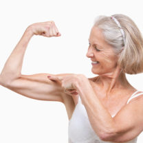 Äldre kvinna spänner sin biceps