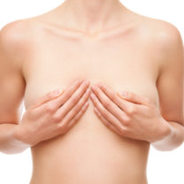 Kvinna håller sina händer över sina bröst