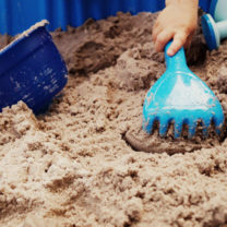 barn leker med plastleksak på strand