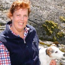 En glad Marie-Ann på en klippa med sin hund
