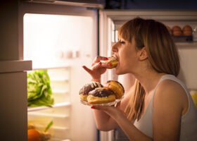 kvinna äter från kylskåpet