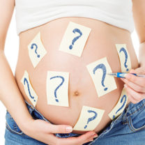 Gravid kvinna som målat frågetecken på magen