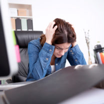 stressad kvinna vid skrivbord