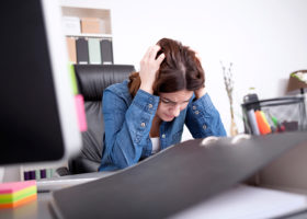 stressad kvinna vid skrivbord