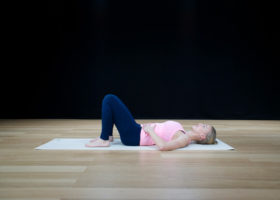 Enkel övning mot smartphone-nacke. Sara Ström ligger på golvet på yogamatta