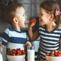 barn matar varandra med jordgubbar