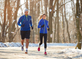 Couple in winter running together in nature