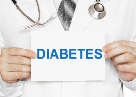 läkare håller skylt där det står diabetes