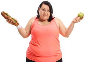 överviktig kvinna med äpple och macka i handen