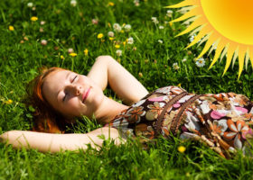 kvinna ligger i gräset och solar