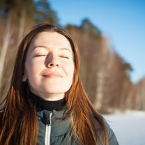 ung kvinna i vinterlandskap blundar och andas