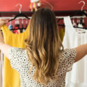 Kvinna väljer mellan två blusar i en butik