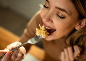 kvinna håller i gaffel med mat