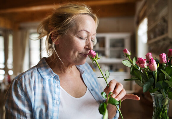 kvinna doftar på rosor