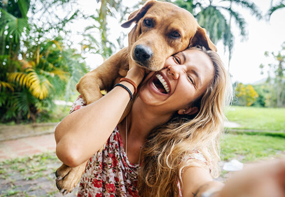 Ung kvinna tar en selfie med sin hund