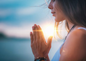 kvinna i profil som sitter i solnedgång och mediterar