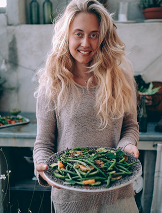 Matkreatören Therese Elgquist håller i en tallrik med grönsaker.