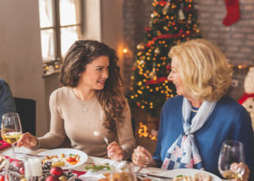 två kvinnor pratar med varandra vid ett julbord