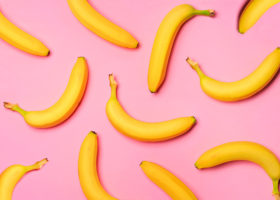 Fruktmönster av bananer över en rosa bakgrund