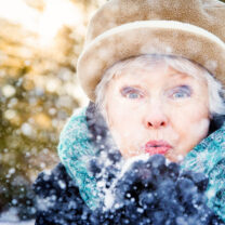 kvinna blåser på snö