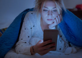 kvinna tittar på mobilen på natten