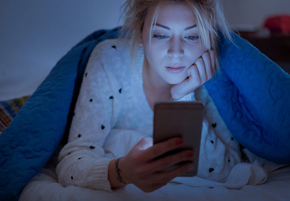 kvinna tittar på mobilen på natten