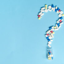 Medicinska piller format som ett frågetecken på blå bakgrund