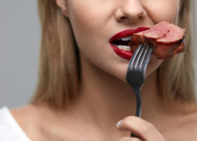 kvinna äter köttbit