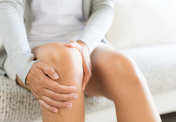Person med muskelsmärta i knä