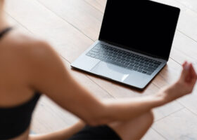 Kvinna mediterar framför dator